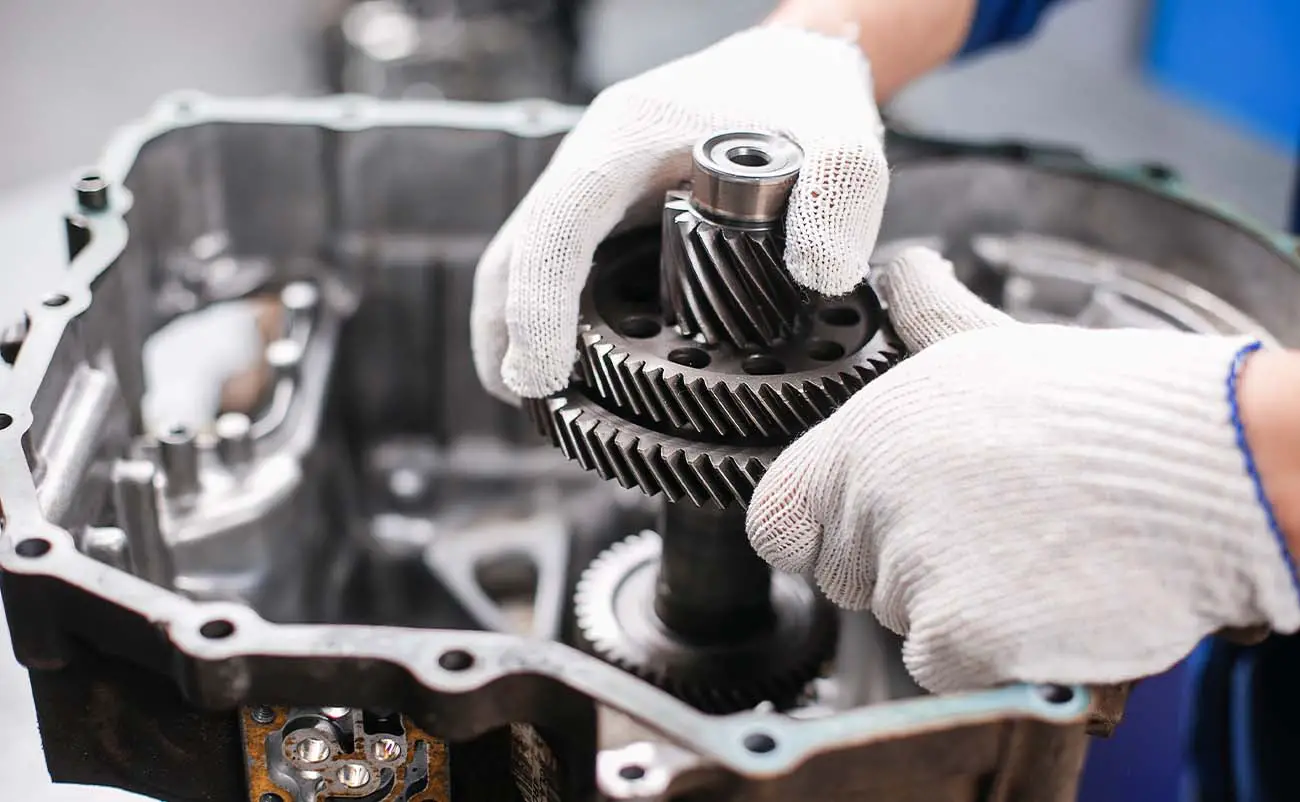 mechanic repairing transmission gear