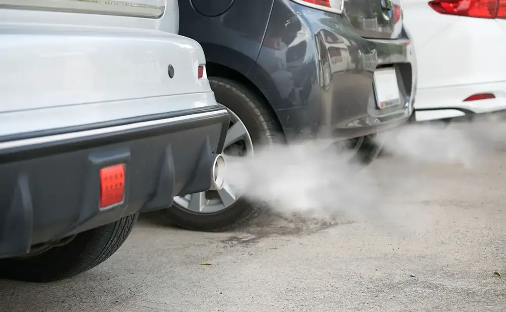 combustion fumes coming out of car exhaust pipe