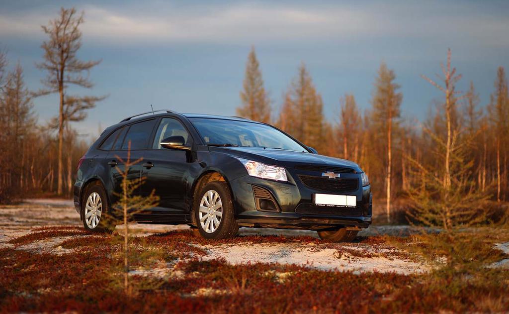 black chevy cruze parked in wide countryside field