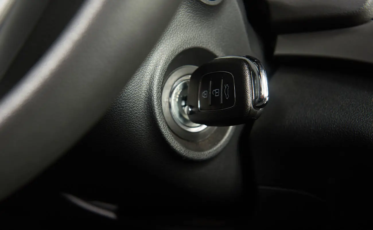 closeup of car key stuck in ignition of modern car