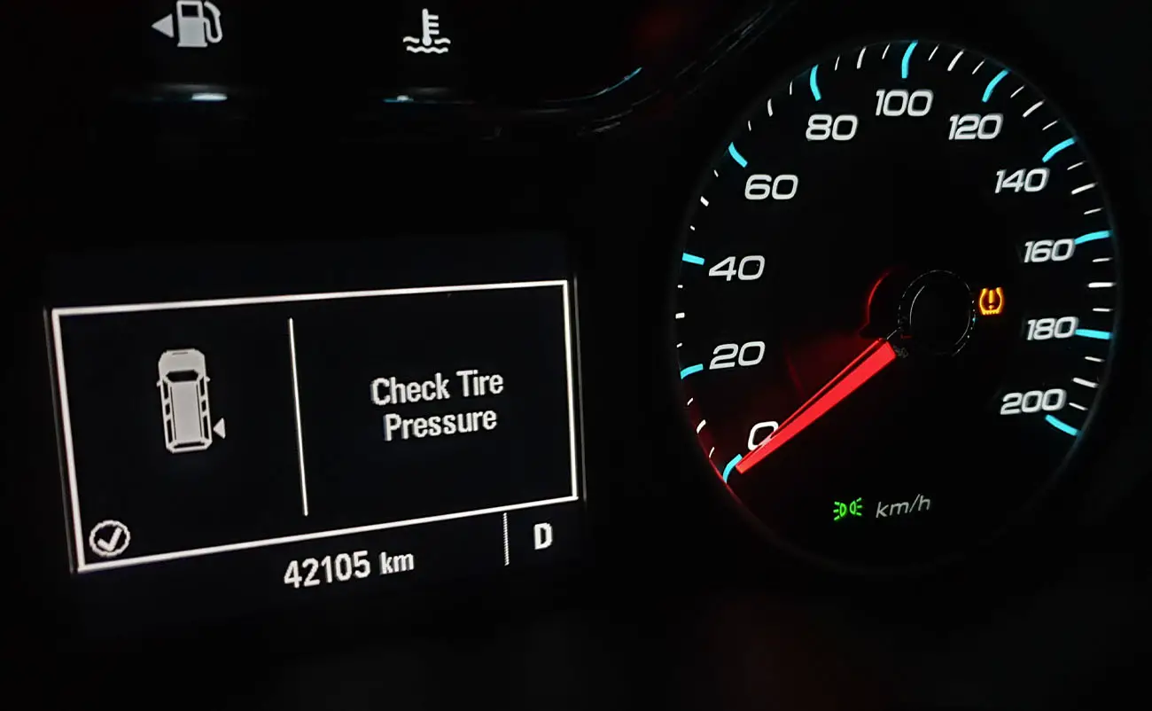 closeup of check tire pressure message and activated tpms tire pressure monitoring system on vehicle cluster