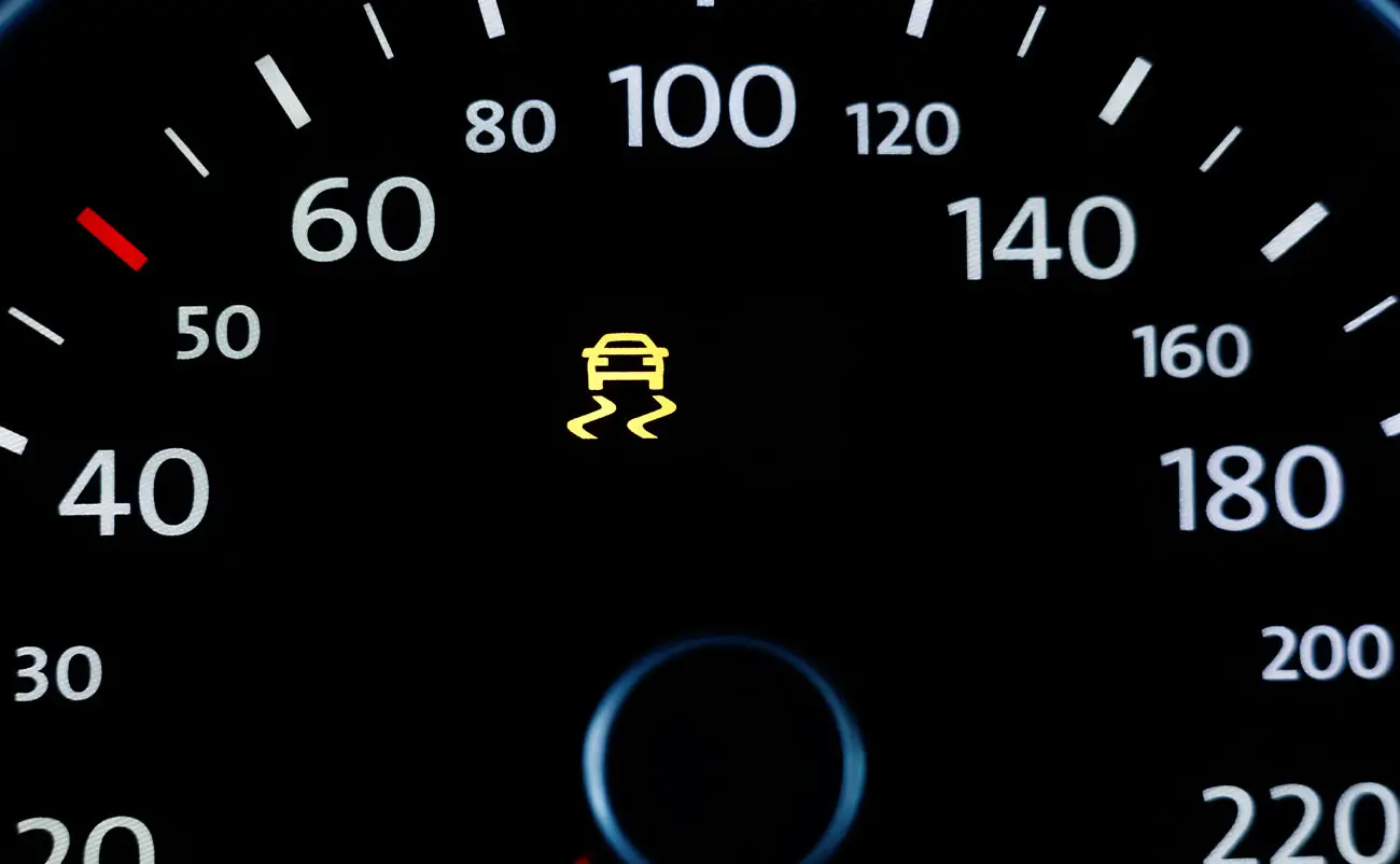 illuminated service traction control light on car dashboard